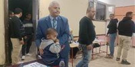 في موقف انساني.. رئيس لجنة في الفيوم يحمل طفل ناخب ليمكن والده من الانتخاب - وضوح نيوز